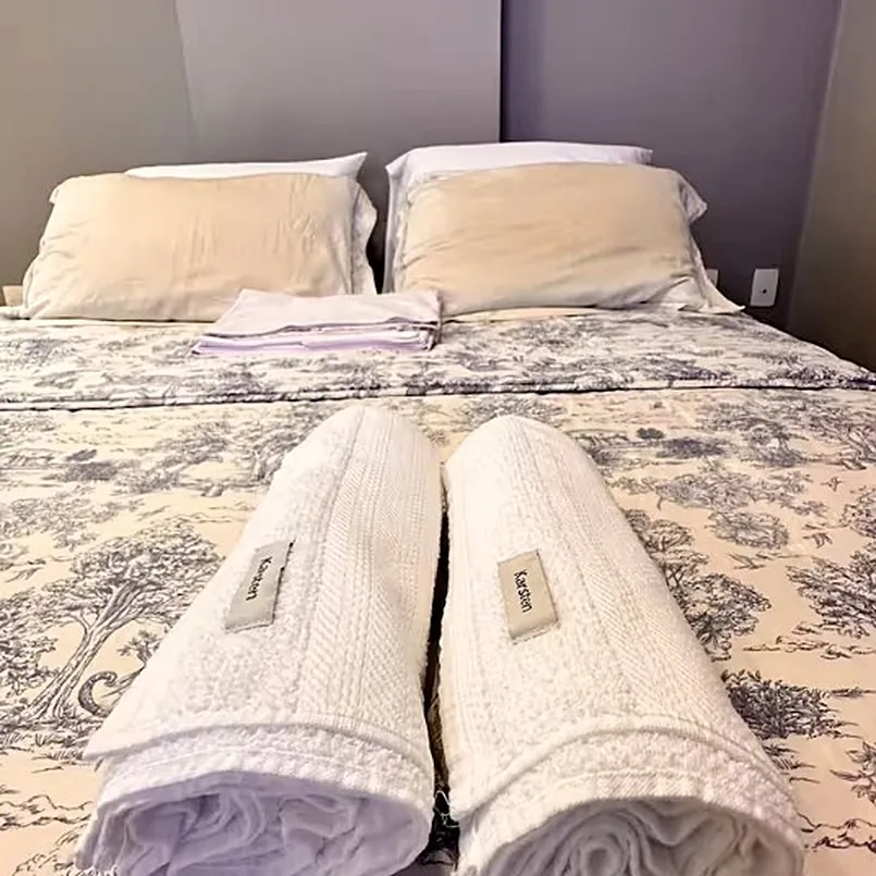 Toalhas dobradas sobre a colcha da cama queen