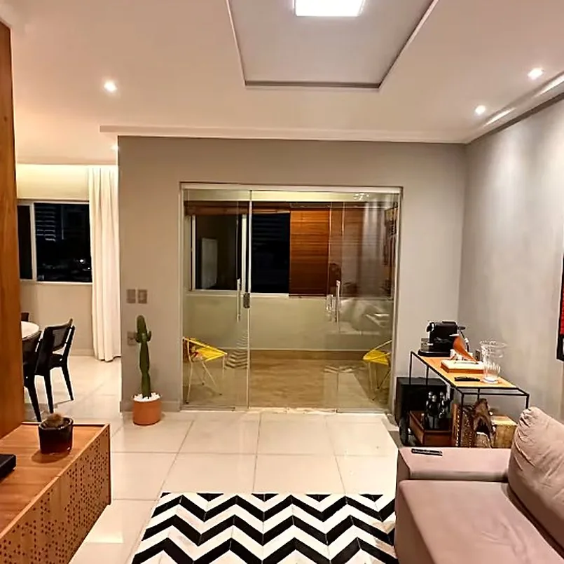 Sala com porta de vidro para a varanda e suas cadeiras amarelas